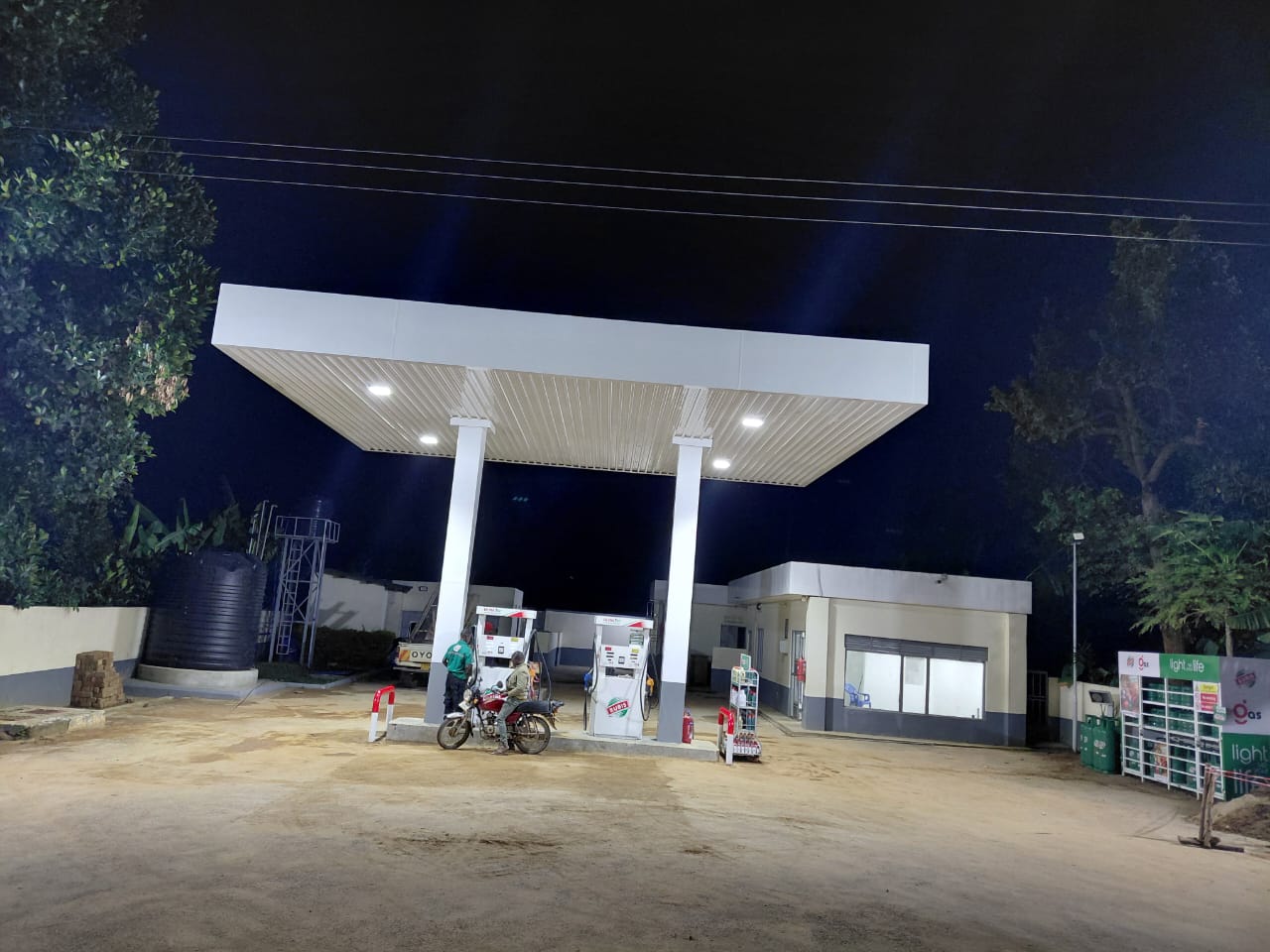 Fuel station steel canopy and forecourt lit at night